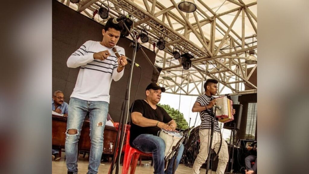 Grupo de músicos tocando vallenato en vivo con acordeón, caja y guacharaca en un escenario durante un evento cultural en Valledupar