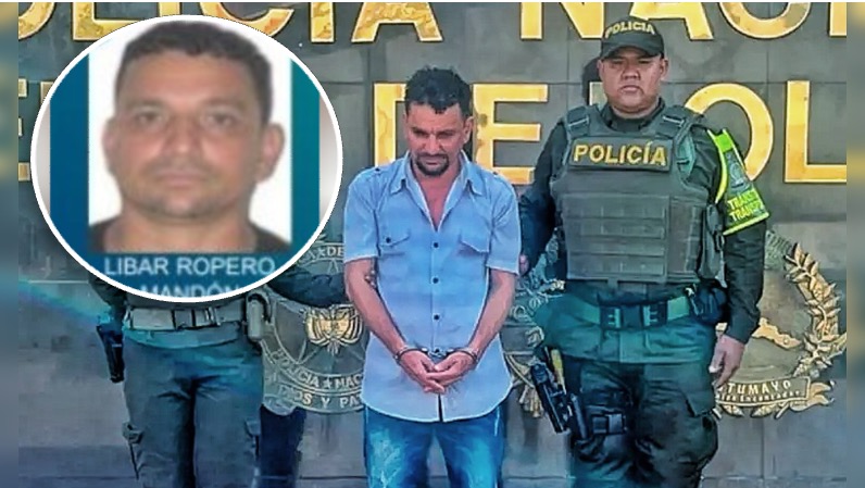 Fotografía de la captura de Libar Ropero Mandón, el profesor condenado por abuso de menores. Aparece esposado, con la mirada baja, vistiendo camisa azul y pantalón de jean, fuertemente custodiado por dos agentes de la Policía Nacional de Colombia. En la esquina superior izquierda hay un recuadro circular con una foto de su rostro para facilitar su identificación pública ante las autoridades del Putumayo.