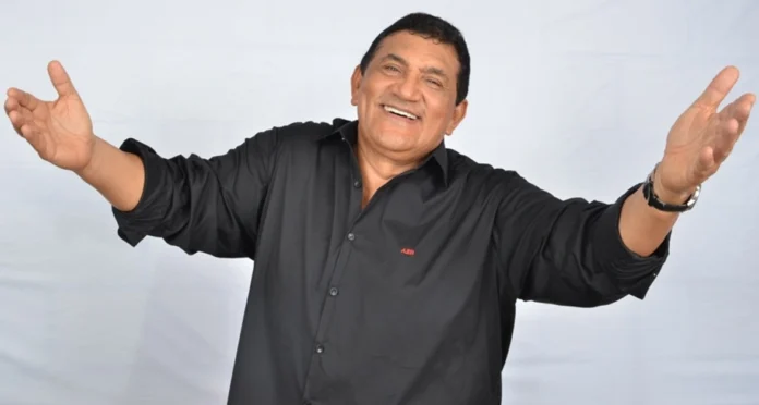 El cantante vallenato Poncho Zuleta interpretando una canción en vivo sobre una tarima, sosteniendo el micrófono con pasión.