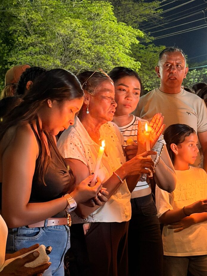 Grupo de familiares afligidos sosteniendo velas encendidas en sus manos durante la velatón nocturna en el Batallón La Popa de Valledupar. En la imagen se observan rostros de profundo dolor rindiendo homenaje a los soldados del Cesar fallecidos en el accidente del avión Hércules.
