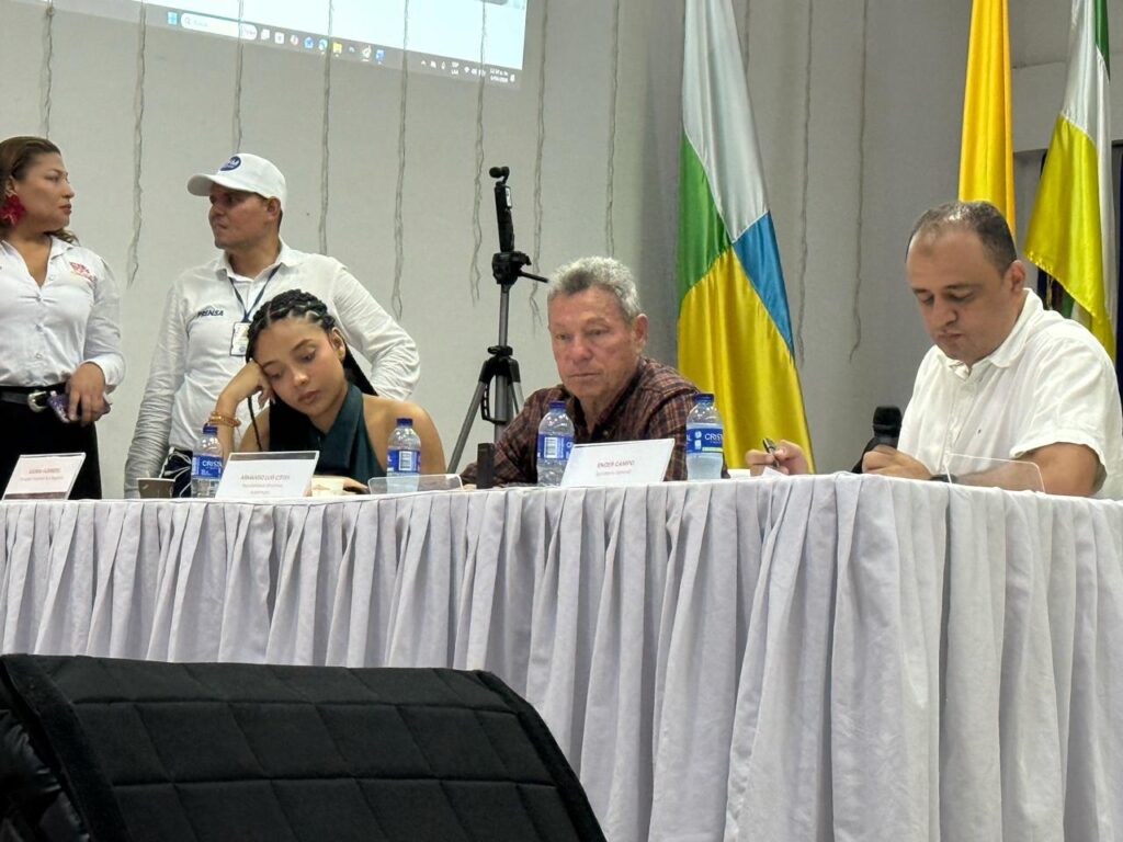 La delegada presidencial Juliana Guerrero, imputada por títulos falsos, con actitud de desinterés y recostando la cabeza sobre su mano durante la reunión decisiva de la UPC en La Jagua de Ibirico.