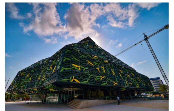 Fachada exterior del Centro Cultural de la Música Vallenata en Valledupar, destacando su imponente diseño arquitectónico con paneles verdes y amarillos en forma de hojas bajo un cielo azul.