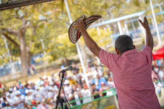 Verseador de espaldas levantando su sombrero vueltiao frente a la multitud en la Plaza Alfonso López durante la Piqueria Mayor.
