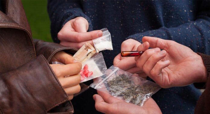 Personas intercambiando sustancias ilícitas como referencia al aumento del consumo de drogas en Curumaní, Cesar