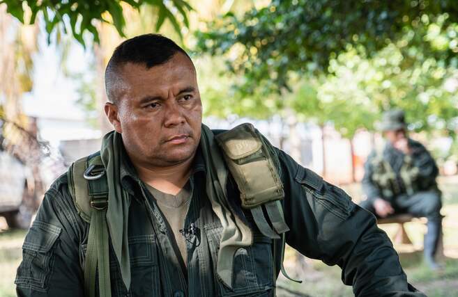 Fotografía de Alexander Díaz, alias Calarcá, cabecilla de las disidencias de las Farc, vistiendo prendas militares verdes durante una entrevista en una zona campestre.