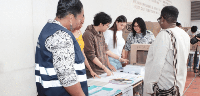 Jurados de votación atendiendo a ciudadanos en una mesa electoral durante una jornada de elecciones en Colombia.