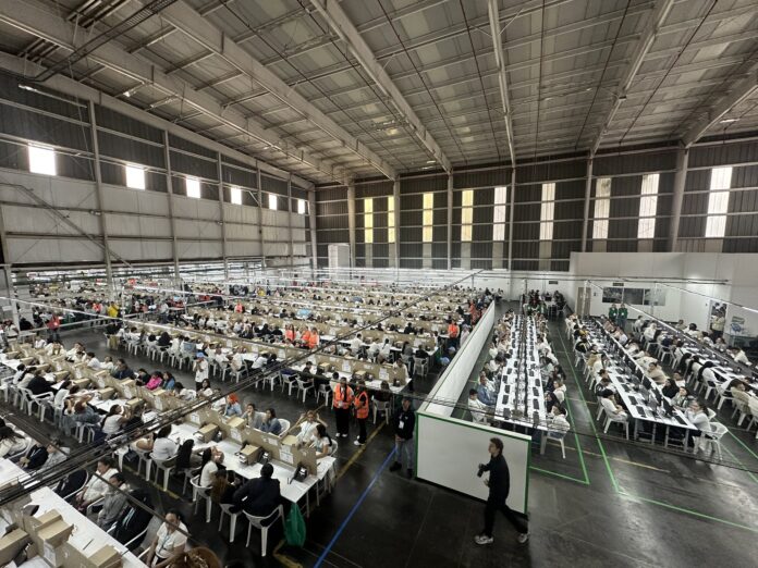 Vista panorámica de cientos de funcionarios y operarios trabajando en un mega centro de procesamiento de datos durante el simulacro de la Registraduría.