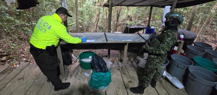 Integrantes del Ejército Nacional y la Policía Antinarcóticos inspeccionan una mesa de procesamiento en un laboratorio del ELN