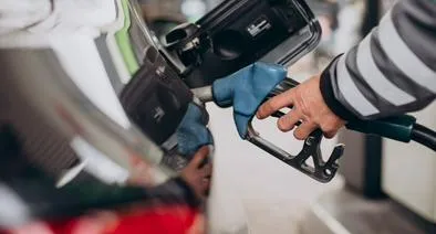 Persona tanqueando vehículo en estación de servicio por aumento de la gasolina en Colombia