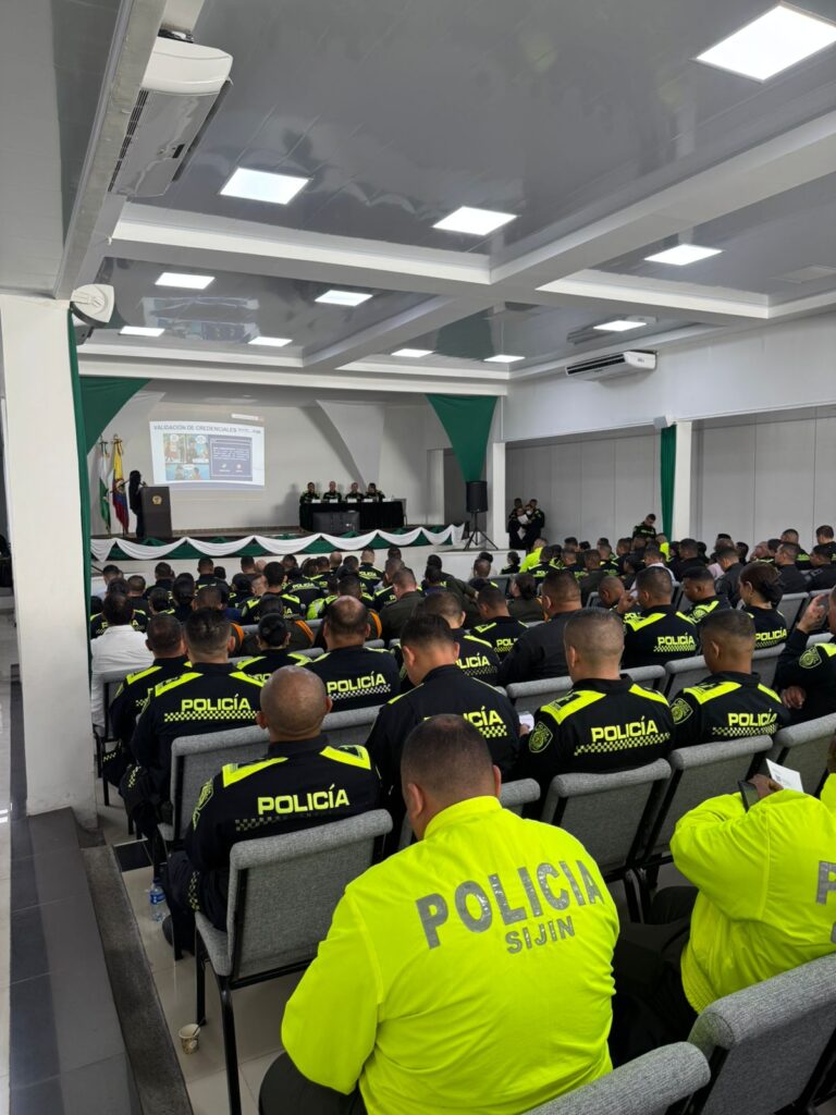 Agentes de la Policía del Cesar sentados en un auditorio observando una presentación sobre la validación de credenciales en el aplicativo 'Comitium'.