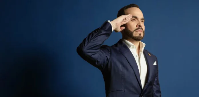 Abelardo de la Espriella, en traje azul oscuro, haciendo un saludo firme de tipo militar de cara a su candidatura. (Esta es la etiqueta más importante. Describe exactamente lo que se ve en la foto para los lectores de pantalla y le da contexto a Google sobre quién es y qué hace).