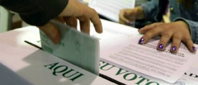 Un sufragante deposita su tarjetón presidencial en la urna mientras los jurados constatan que miles de ciudadanos están habilitados para votar en el Cesar.
