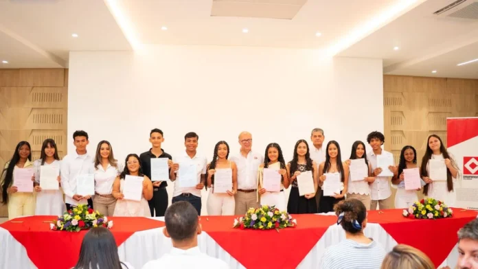 Los 19 nuevos becarios del Programa de Becas Drummond 2026 sosteniendo sus certificados durante la ceremonia de aniversario.