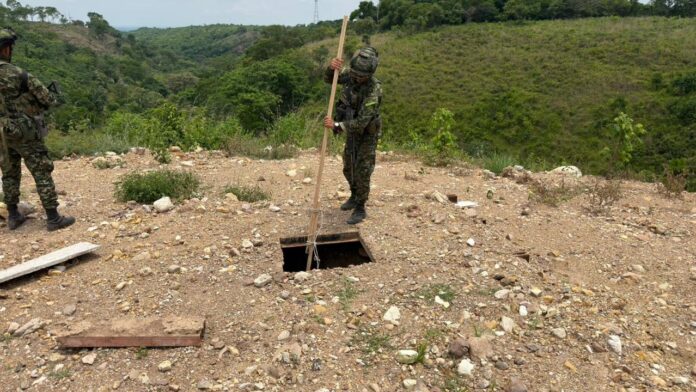 Un soldado del Ejército Nacional inspecciona la entrada oculta a un túnel de un megalaboratorio subterráneo en Aguachica.