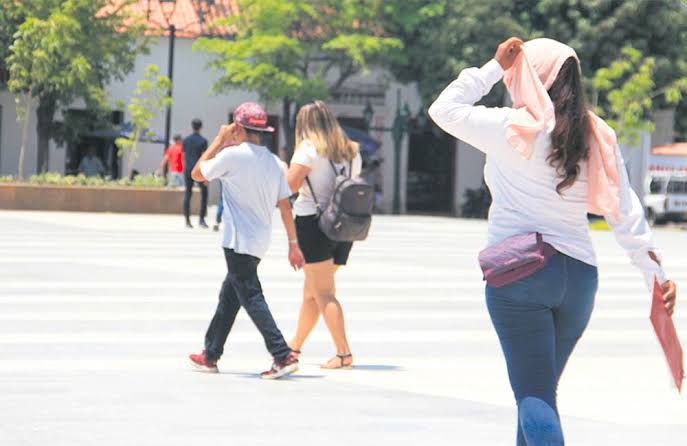 Personas se protegen del intenso calor en medio de la alerta por el fenómeno de El Niño.
