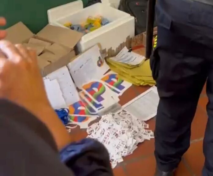 Autoridades civiles y policiales inspeccionan los folletos incautados debido a la prohibición de propaganda política durante las elecciones presidenciales en la UPC.