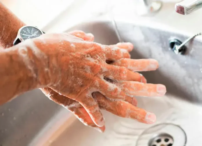 Persona procediendo a lavarse las manos con agua y jabón para evitar bacterias mortales.