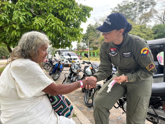Integrante de la Fuerza Aeroespacial Colombiana brinda atención y acompañamiento a una mujer mayor durante la jornada médica en Pueblo Bello.