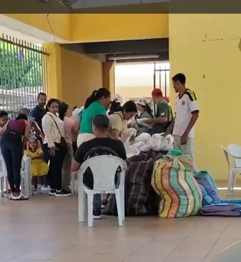 Personas hacen fila en un espacio comunitario del barrio Lorenzo Morales en Valledupar para recibir bolsas con ropa en medio de denuncias por presunto trasfondo político.