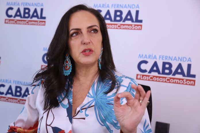 Despedida de Cabal: Fotografía de la líder política hablando frente a un cartel con su eslogan oficial.