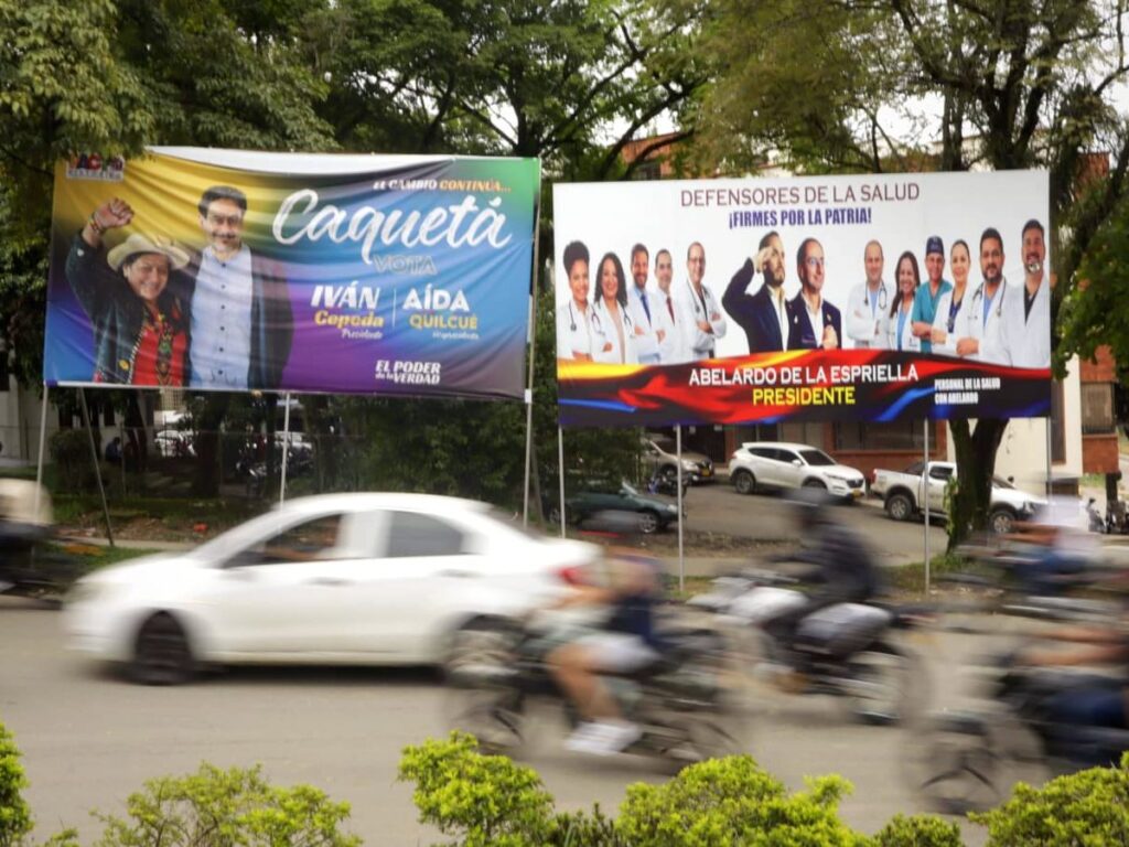 Vallas publicitarias enfrentadas de los candidatos presidenciales Iván Cepeda y Abelardo de la Espriella en una avenida colombiana.