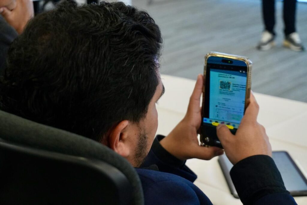 Testigo electoral revisa en su celular información del proceso durante la segunda vuelta presidencial 2026.