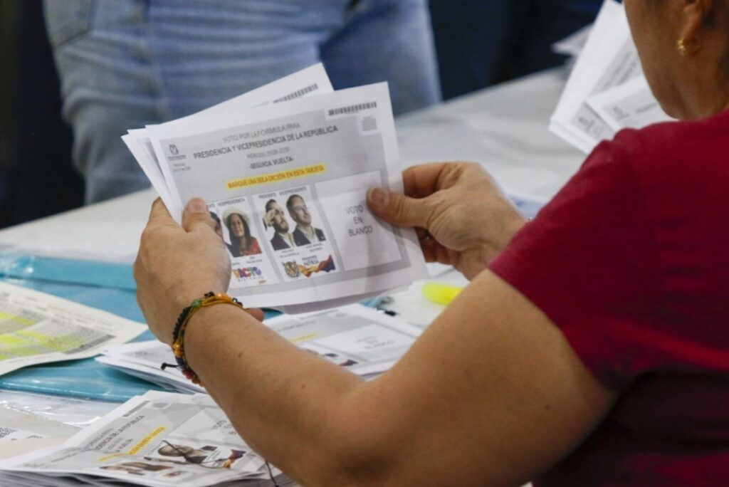 Funcionaria revisa tarjetas electorales durante el proceso de escrutinio y conteo de votos en Colombia.