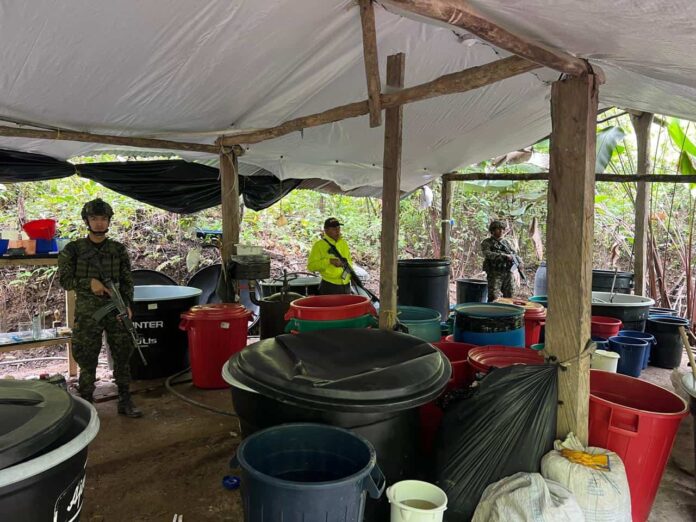 Uniformados inspeccionan canecas y equipos dentro de un laboratorio clandestino ubicado en Caño Seco, San Alberto.