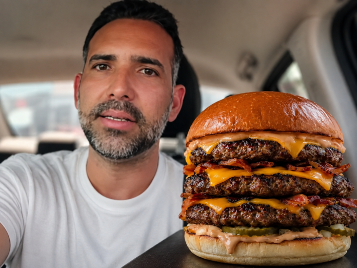Hombre junto a una hamburguesa triple que causó polémica en redes sociales