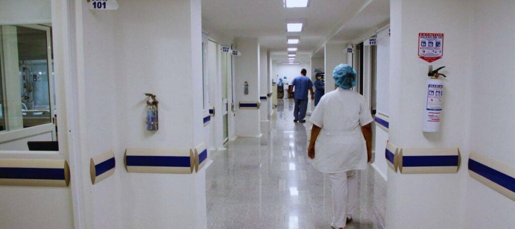 Profesional de la salud recorre un pasillo hospitalario durante su jornada laboral