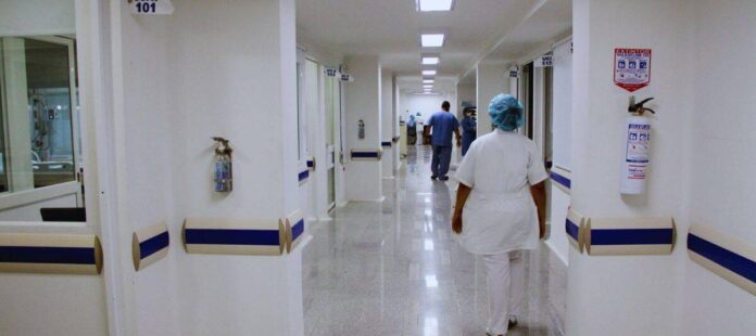 Profesional de la salud recorre un pasillo hospitalario durante su jornada laboral
