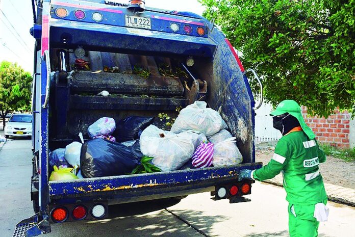Trabajador realiza labores de recolección de residuos junto a un camión de basura en Valledupar