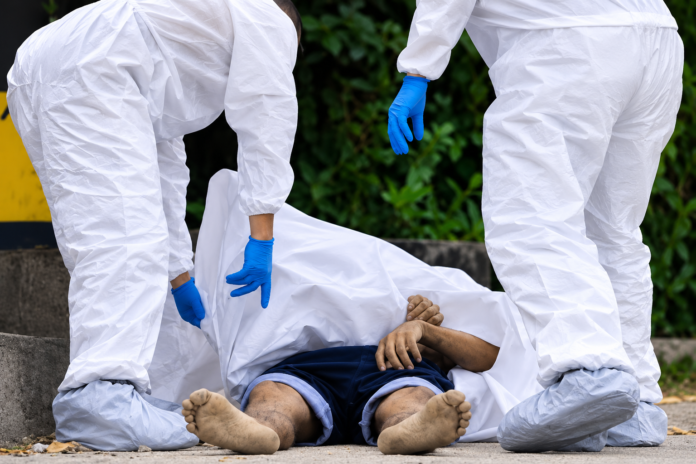 Personal forense realiza la inspección de un cuerpo durante una investigación por homicidio.