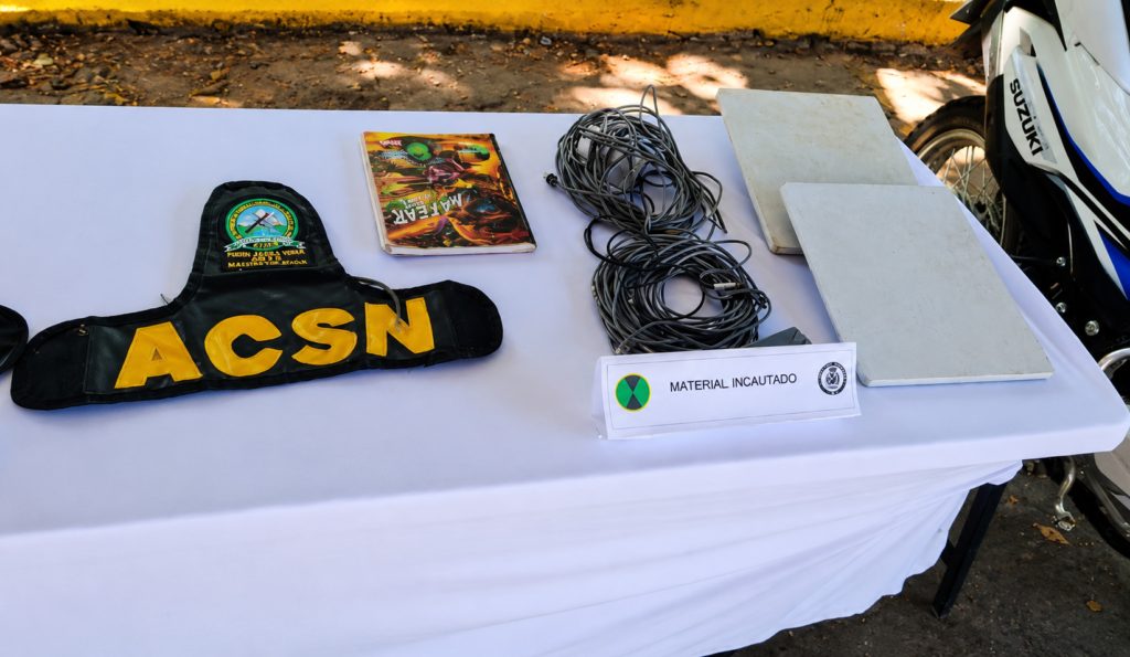 Distintivo con las letras ACSN y otros elementos incautados durante un operativo en El Copey.