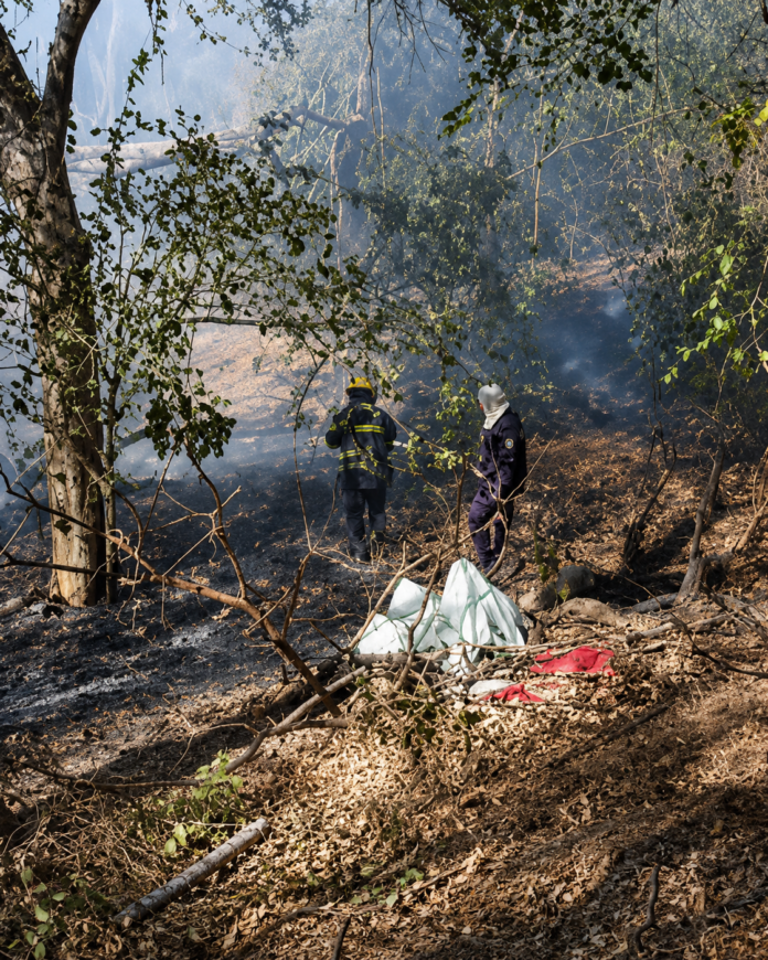 Bomberos recorren una zona quemada tras controlar un incendio cerca del río Guatapurí en Valledupar.