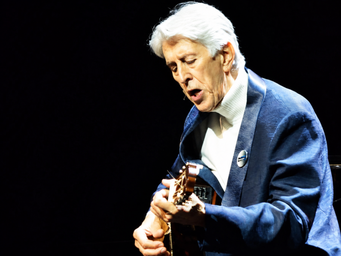 Héctor Ochoa interpreta una canción con su guitarra durante una presentación musical.
