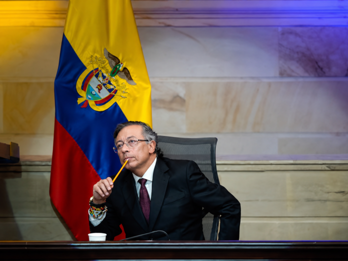 Gustavo Petro sentado junto a la bandera de Colombia durante una reunión oficial