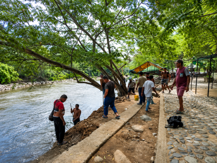 Vendedores y trabajadores permanecen junto al río Guatapurí en el balneario Hurtado de Valledupar.