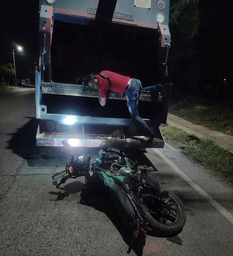 Escena posterior al choque de una motocicleta contra un camión recolector de basura en la vía a Los Corazones