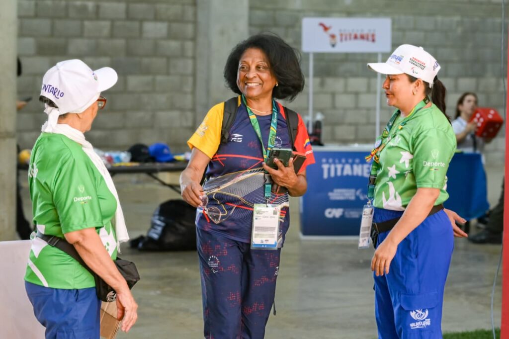 Voluntarias conversan con una integrante de una delegación durante los Juegos Parasuramericanos Valledupar 2026.