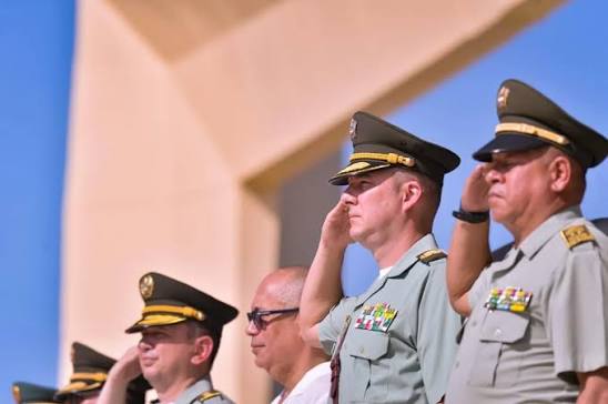 Oficiales de las Fuerzas Militares rinden honores durante una ceremonia oficial en Colombia