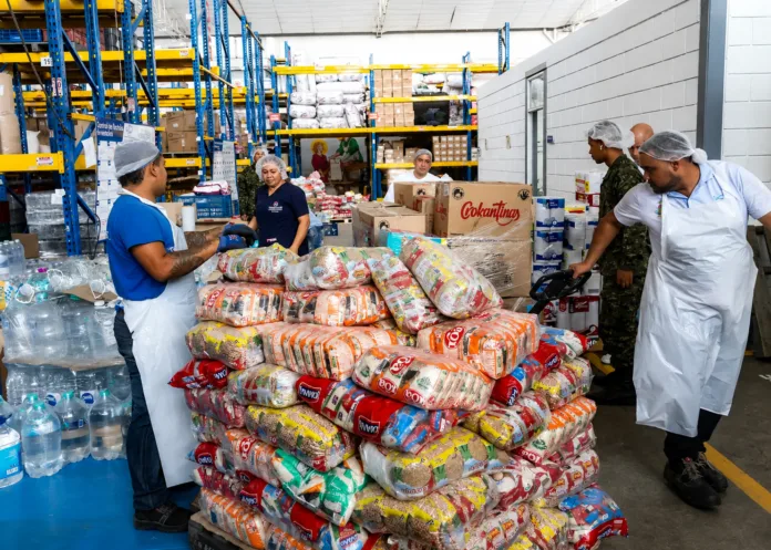 Personal organiza alimentos, agua y suministros donados para damnificados del terremoto en Colombia
