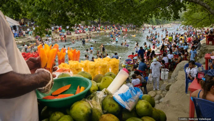 Vendedor de frutas y visitantes en el balneario Hurtado, a orillas del río Guatapurí en Valledupar