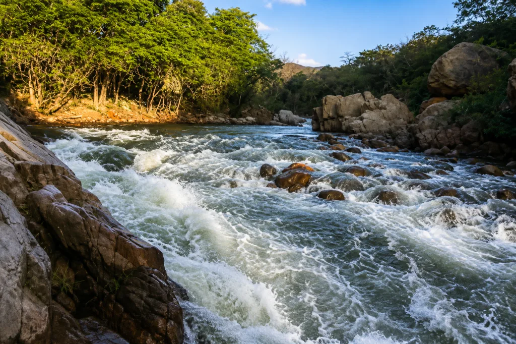 Vista del río Guatapurí con fuerte caudal entre rocas y vegetación en zona rural de Valledupar