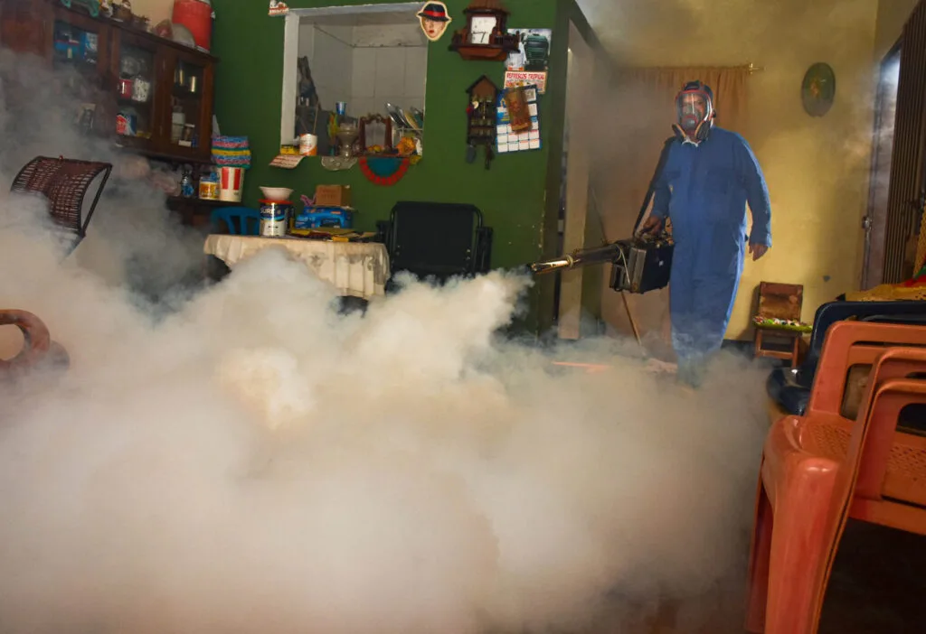 Operario realiza fumigación dentro de una vivienda para prevenir el dengue