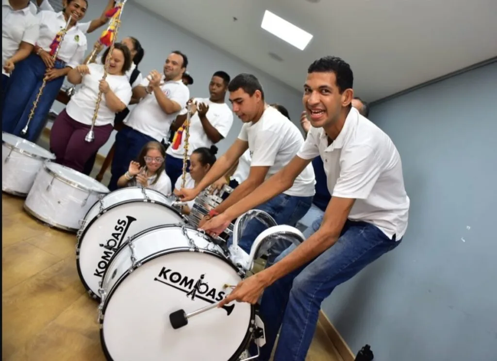Jóvenes sonrientes tocando bombos en una actividad de inclusión social y taller de música en Valledupar.
