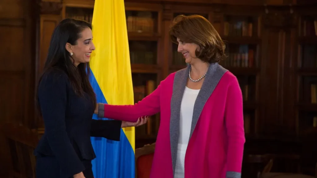 Adela María Maestre Cuello durante un encuentro diplomático junto a la bandera de Colombia