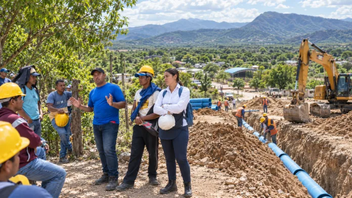 Obreros del acueducto de La Junta participan en una reunión junto a una ingeniera y líderes comunitarios durante las obras del proyecto
