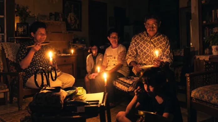 Familia iluminada con velas durante un posible racionamiento de energía en el Cesar