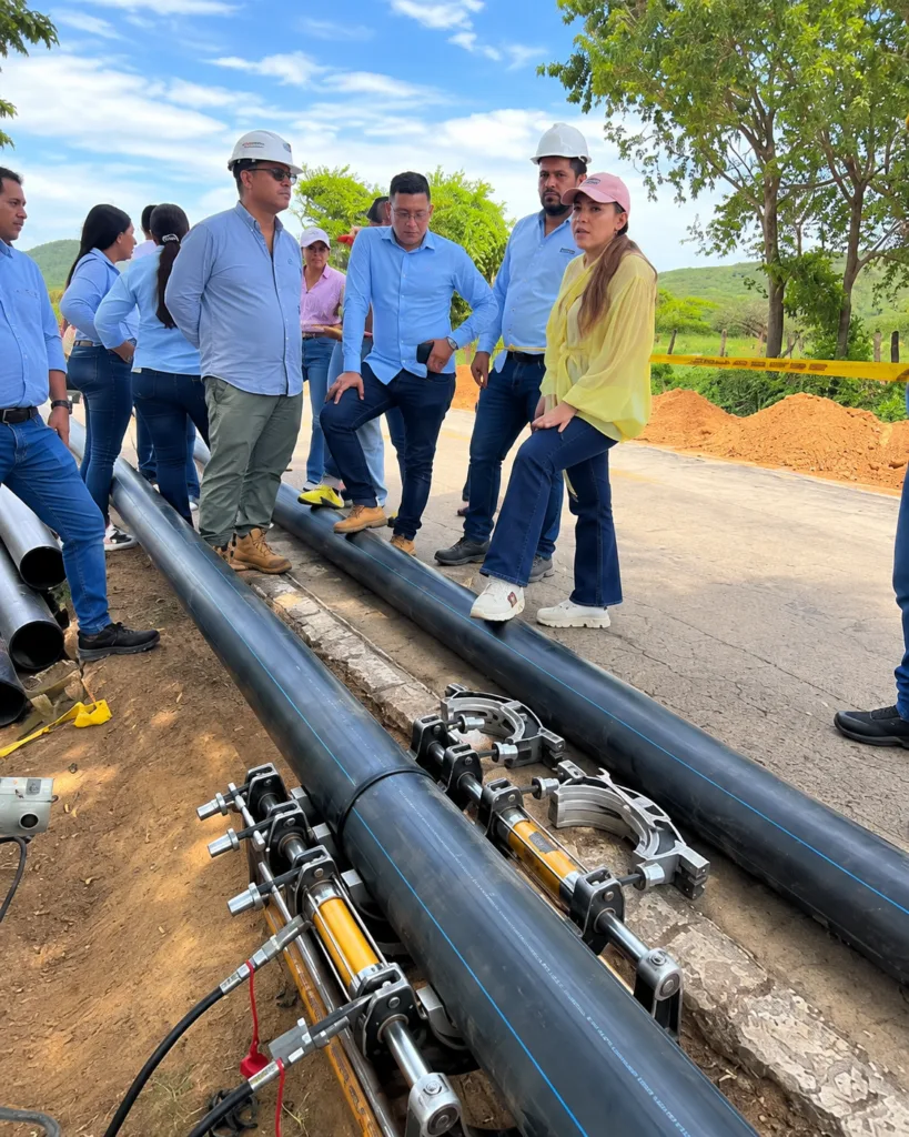 Andreína García, de blusa amarilla, inspecciona tuberías instaladas en las obras del acueducto de La Junta durante una visita técnica.